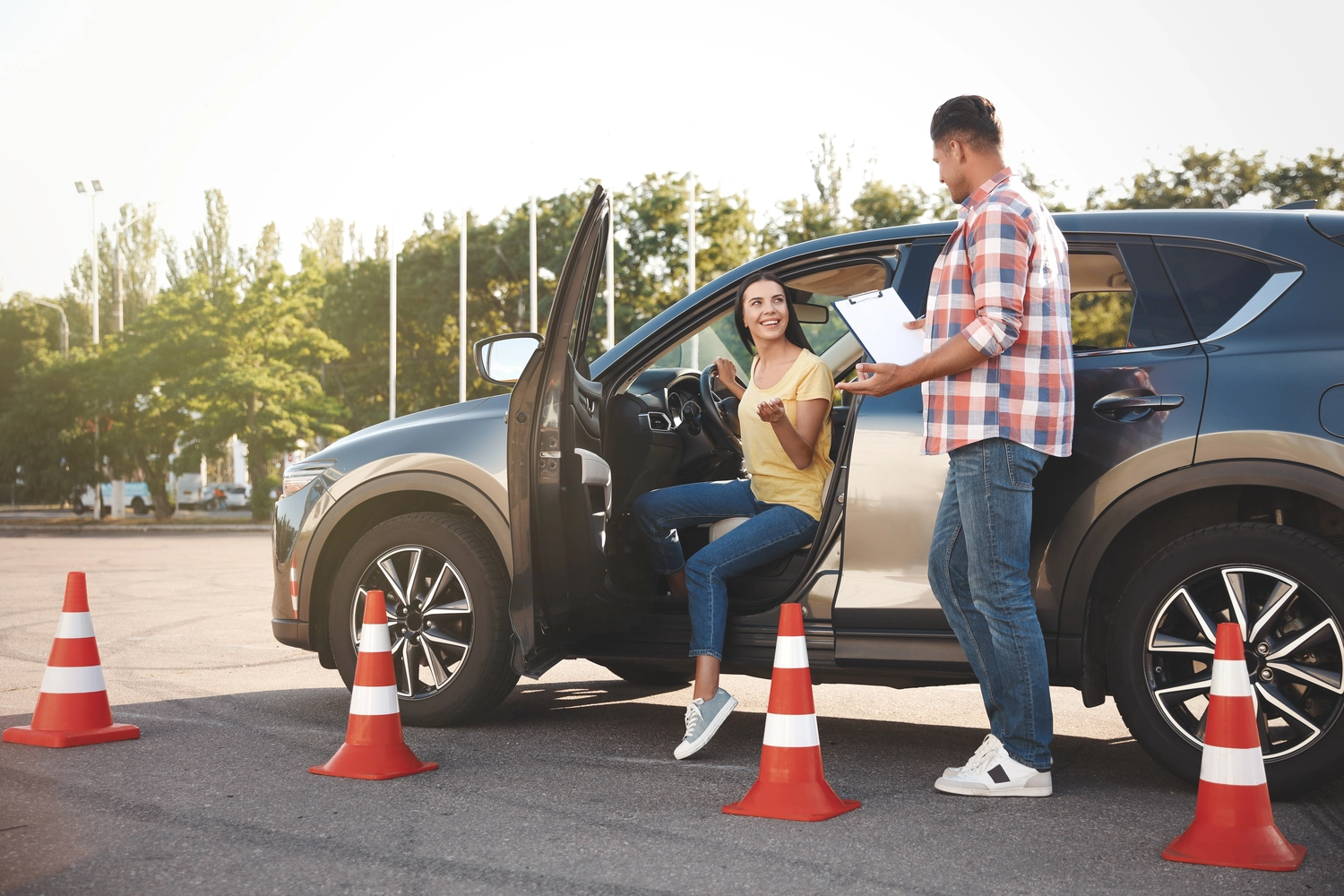 Fahrschule Take - Führerschein Klasse - Fahrlehrer mit Klemmbrett und sein Fahrschüler neben dem Auto im Freien. Fahrprüfung